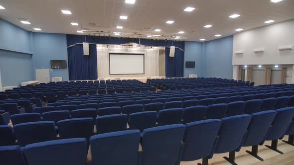 Projection Screen on Stage and Chairs in Conference Hall