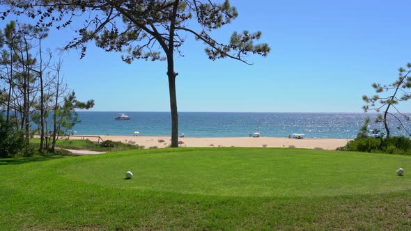 Panning Shot From Shot Nice Looking Trees and a Beach to a Green Golf Field in Vale Do Lobo Portugal