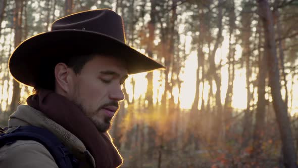 Portrait of a Man in a Hat with a Backpack in the Forest