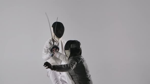 The View From Behind Two Female Fencers Fighting in the Tournament