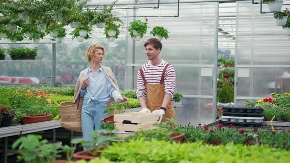 Young Woman Shopping for Decorative Plants on a Floristic Greenhouse Market