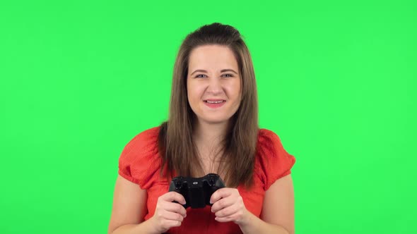 Portrait of Cute Girl Playing a Video Game Using a Wireless Controller with Joy and Rejoicing in