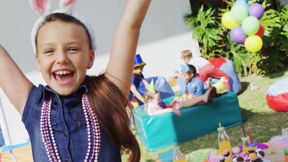 Portrait of smiling girl with arms raised during birthday party 4k