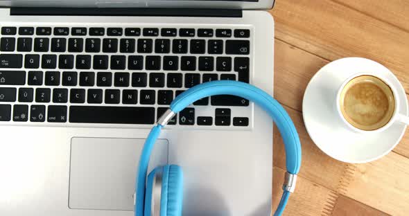 Cup of coffee with laptop and headphones