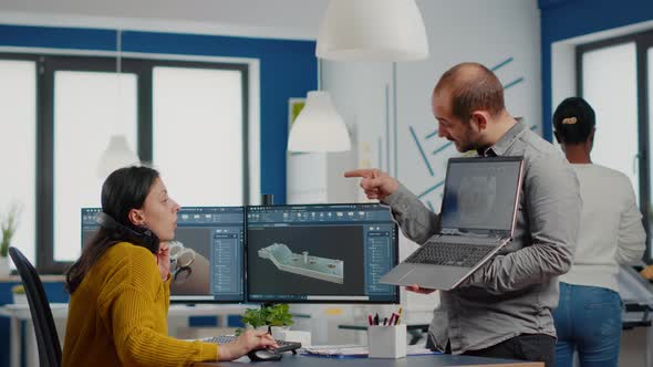 Man Project Supervisor Holding Laptop and Pointing on Display