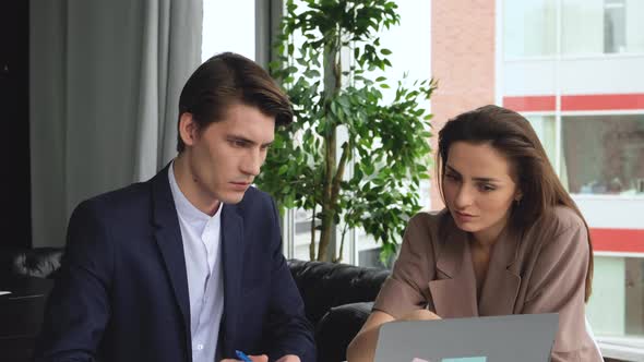 Man and woman work in comfortable modern office sitting at the table. Working process