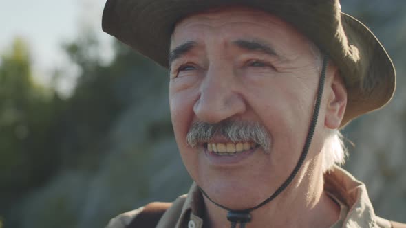 Senior Male Tourist Looking through Binoculars and Smiling