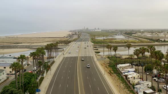 Aerial view gliding down a coastal street to sparse summer traffic due to the COVID 19 coronavirus o