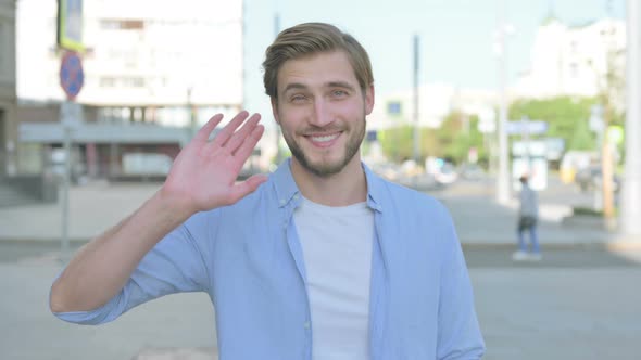 Welcoming Man Waving Hand for Hello Outdoor