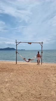Men and Women Relaxing in Hammock on the Beach in Pattaya Thailand Ban Amphur Beach