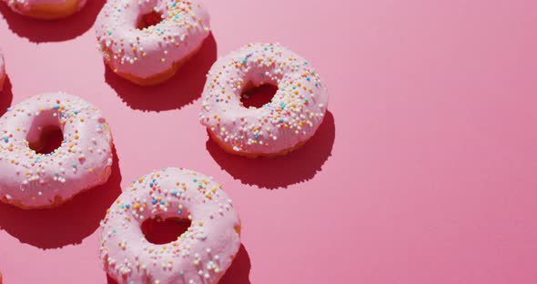 Video of donuts with icing on pink background