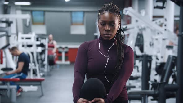 A Black Woman Listening Music and Warming Up in the Gym