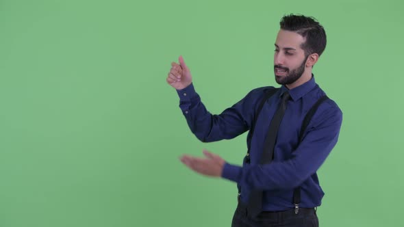 Happy Young Bearded Persian Businessman Snapping Fingers and Showing Something