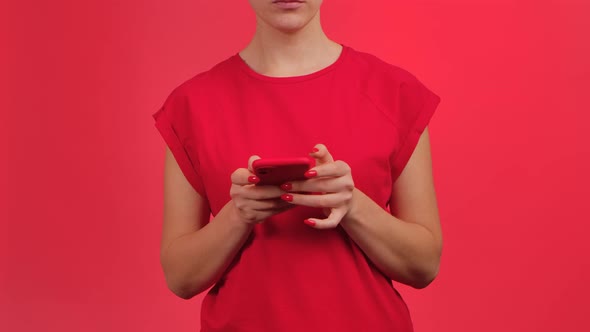 Woman Texting on Smartphone and Demonstrates Phone with Green Workspace Mock Up Screen on Red