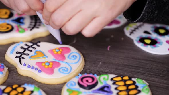 Step by step. Decorating sugar skull cookies with different color royal icing.