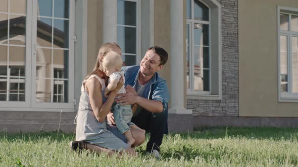 Affectionate Parents Kissing Toddler