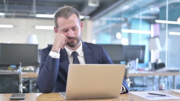 Sleepy Young Businessman Having Quick Nap on Office Desk