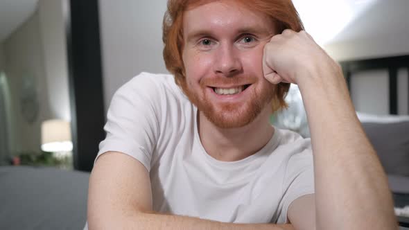 Smiling Casually Sitting Redhead Man