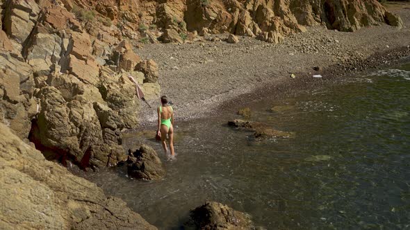 Rear View Beautiful Slim Fit Body Woman in Green Swimsuit Sunbathing Walks Out of Turquoise Water of