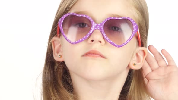 Baby Posing for Video Cameras with Glasses. White Background. Close Up