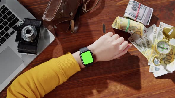 Woman Using Smartwatch with Chroma Key Top View Money Cash Compass Photo Camera and Laptop Computer