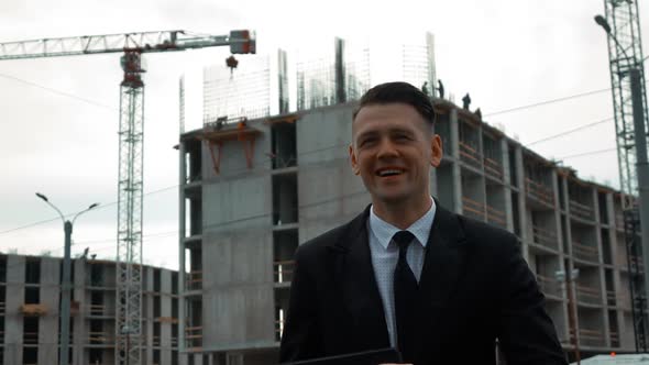 Businessman Using Digital Pad Near New Construction