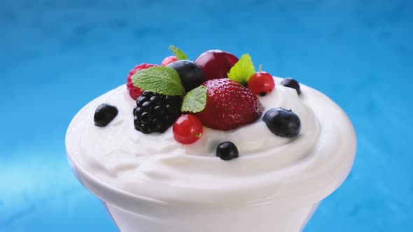 Bowl of yogurt with wild berries: strawberry, blueberry, raspberry