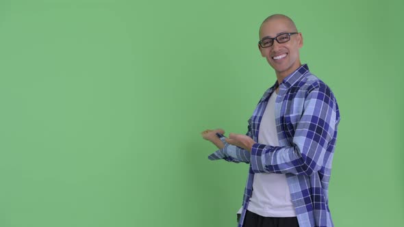 Happy Bald Hipster Man Talking While Showing To Back