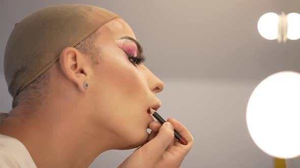 Side View Extravagant Caucasian LGBT Woman with Makeup on Eyes Applying Lip Pencil in Slow Motion