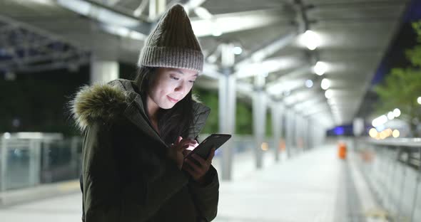 Asian Woman use of mobile phone in city at night