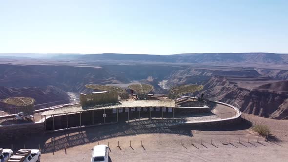 SUVs are parked at the top of the cliff of the huge Fish River Canyon, Namibia