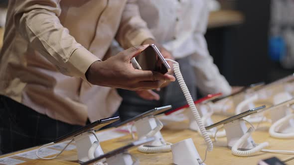 Afroamerican Man and Woman are Shopping in Digital Equipment Store Taking Exhibition Samples of