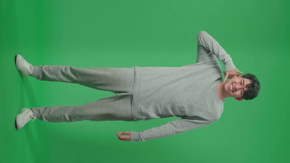 Full Body Of Cheerful Man Making A Phone Call Hand Gesture While Standing In Front Of Green Screen