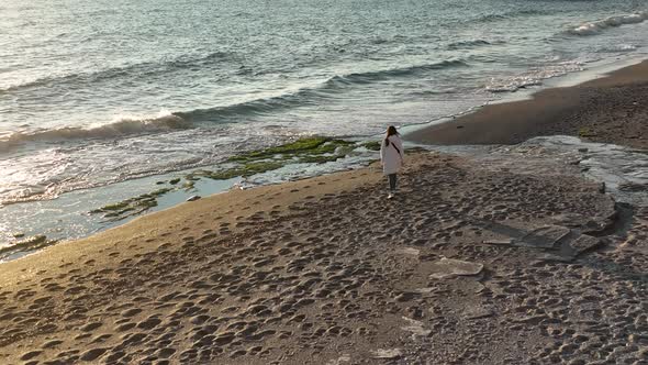 A girl walks on the beach 4 K Aerial View
