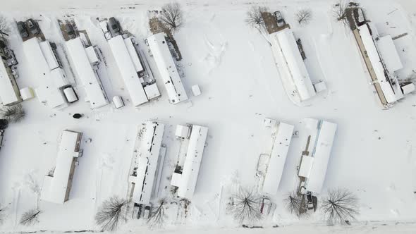 Top down aerial view over mobile home park in winter with snow covered ground.