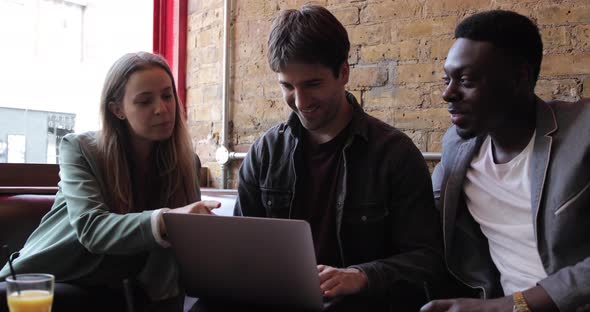 Happy friends working together with a laptop on a break