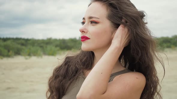 Pretty Woman Touching Hair on Beach