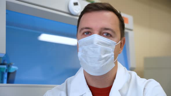 Male Chemical Lab Researcher in Medical Mask Says No and Shakes His Head in Biomedical Laboratory