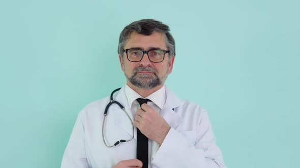 Portrait of a Senior Doctor in White Suit with Stethoscope Correction Tie on Blue Background