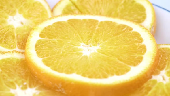 Close up fresh valencia orange sliced with white background shallow focus and slowly rotating.