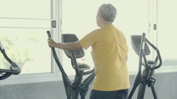 Senior man asian workout in the gym, elder caucasian do activity exercise for cardio in fitness.