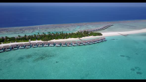 Aerial scenery of tranquil seashore beach lifestyle by blue water with white sand background of a da