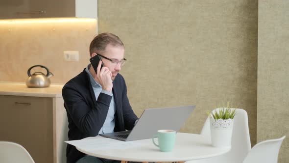 Remote Job. A Man Is Working with Documents on Laptop Remotely at Home. A Business Man Is Using