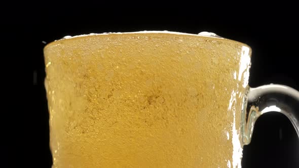 Pouring blonde beer on pint glass, bobbles and foam