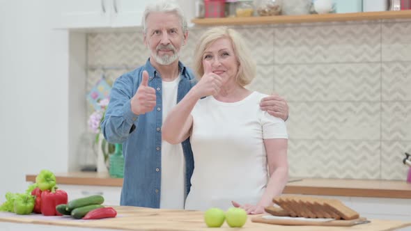 Loving Old Couple Making Heart Shape By Hands While in Kitchen