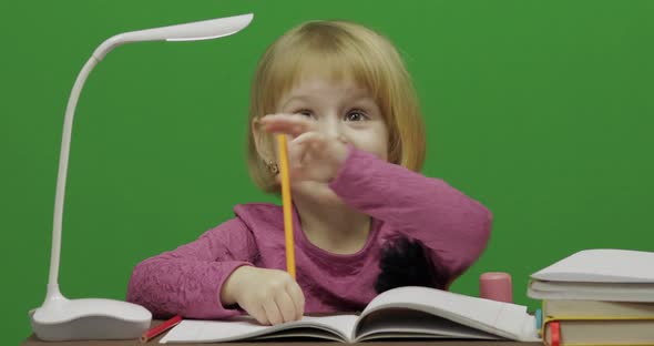 Girl Drawing at the Table. Education Process in Classroom. Chroma Key