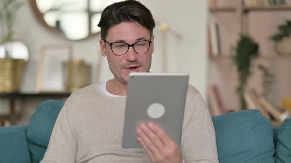 Video Call on Tablet By Middle Aged Man at Home