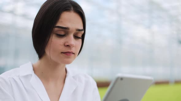 Agricultural Engineer in Greenhouse Wearing White Coat Working Ot Tablet Computer To Test Pant's