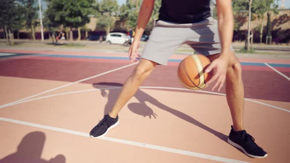 Adult Male Basketball Player Dribbling the Ball on the Basketball Playground