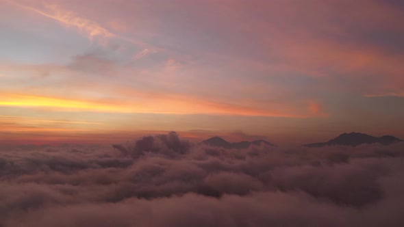 The beautiful fiery orange sunset view above the clouds of Bali, Indonesia - Aerial shot